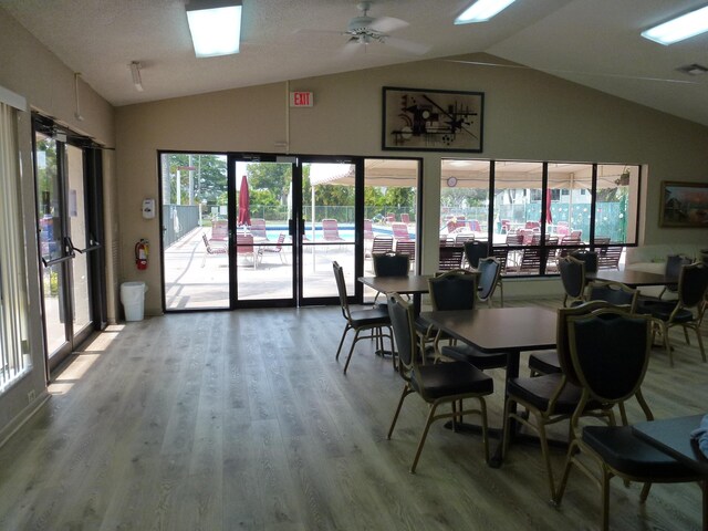 dining room with ceiling fan, lofted ceiling, and wood-type flooring