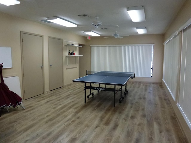 recreation room with ceiling fan, light wood finished floors, and visible vents