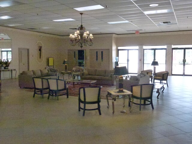 dining area featuring a healthy amount of sunlight, a paneled ceiling, and light tile patterned floors