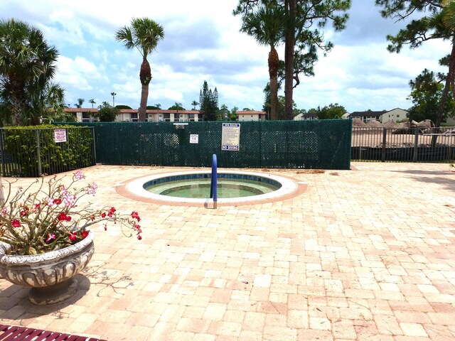 view of pool with a community hot tub and a patio area