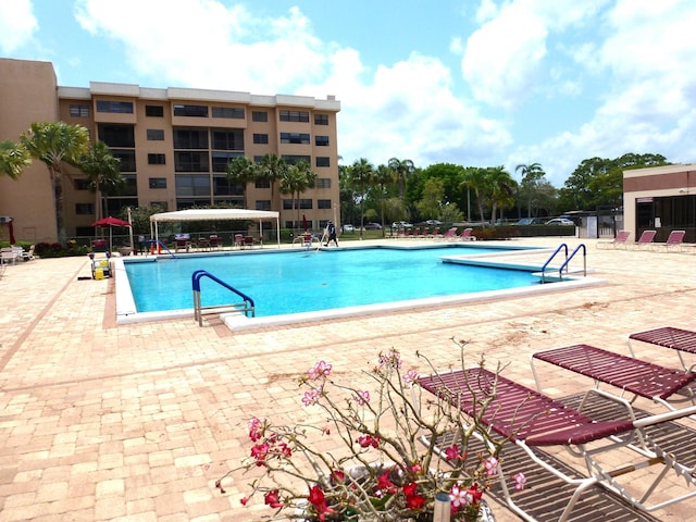 community pool featuring a pergola, a patio, and fence