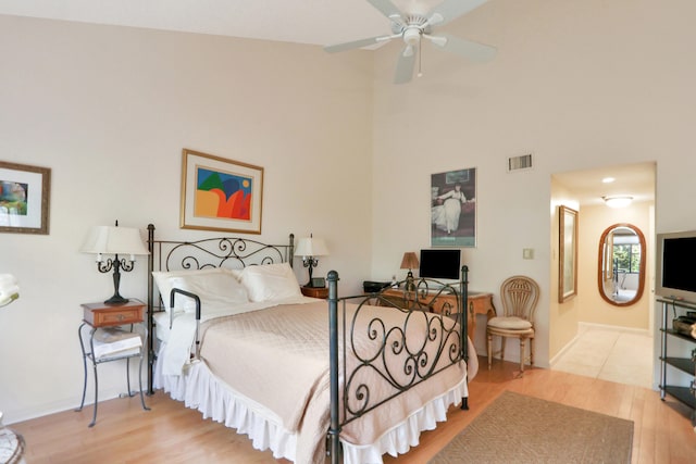 bedroom with light hardwood / wood-style floors, ceiling fan, and ensuite bathroom