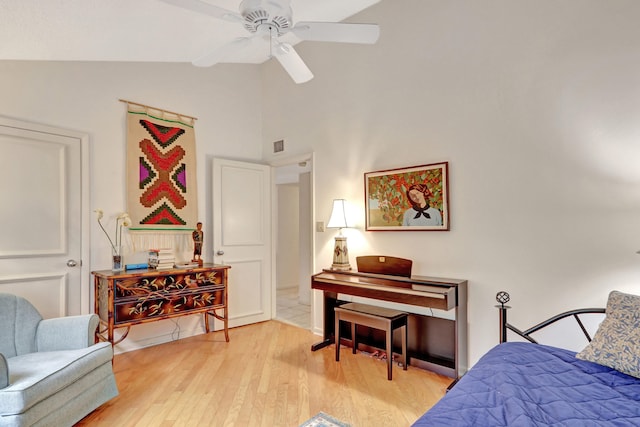 bedroom with ceiling fan, light hardwood / wood-style flooring, and high vaulted ceiling