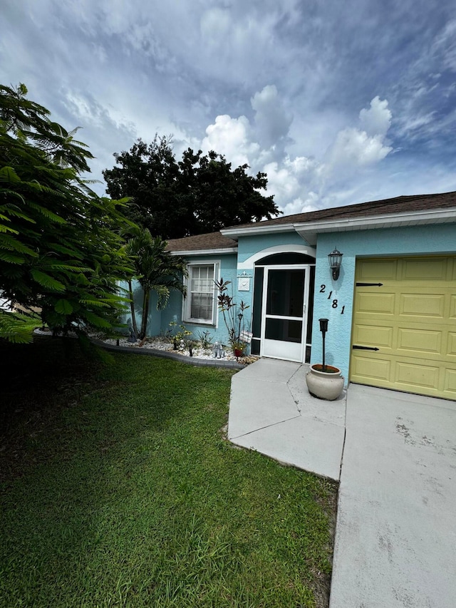 ranch-style house with a garage and a front yard