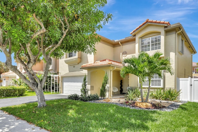 mediterranean / spanish-style home with a garage and a front lawn