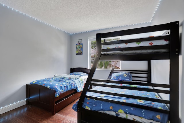 bedroom featuring wood-type flooring and a textured ceiling