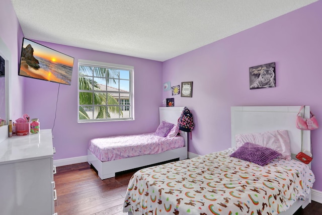 bedroom featuring wood-type flooring and a textured ceiling