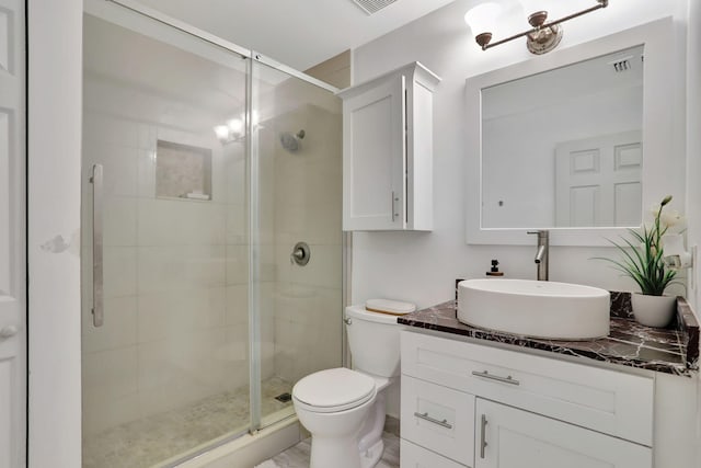 bathroom with vanity, a shower with shower door, and toilet