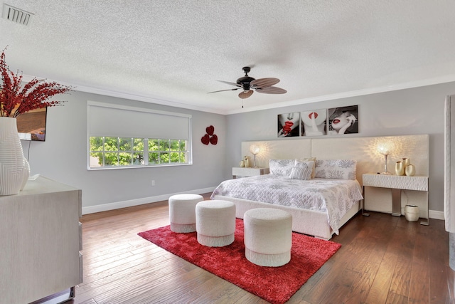 bedroom featuring ornamental molding, a textured ceiling, ceiling fan, and dark hardwood / wood-style flooring