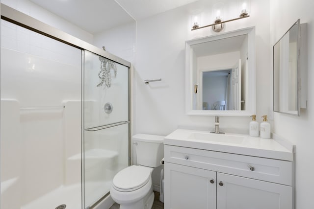 bathroom with toilet, an enclosed shower, and vanity