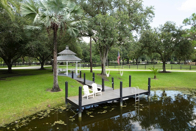 dock area featuring a water view, a yard, and a gazebo