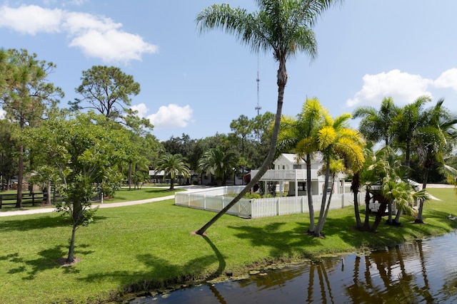 view of property's community with a lawn and a water view