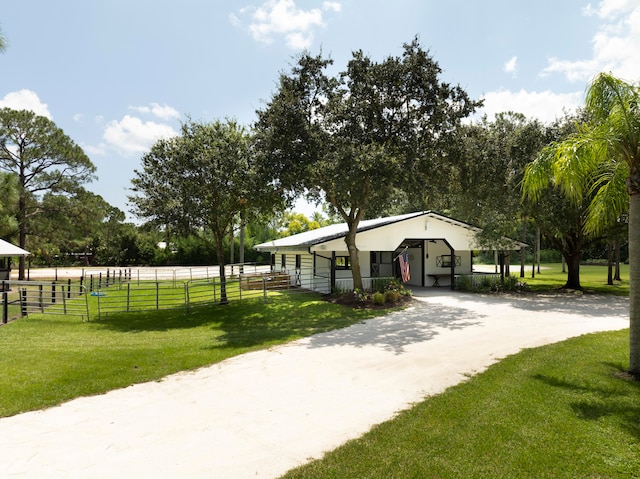 view of home's community featuring a lawn, a rural view, and an outdoor structure