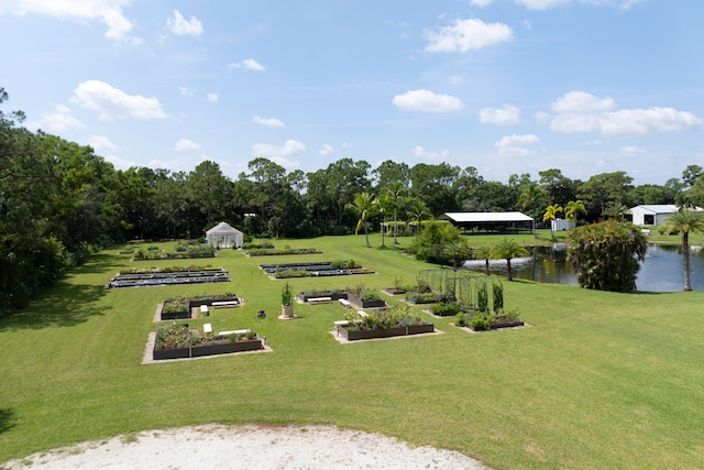 view of home's community with a water view and a yard