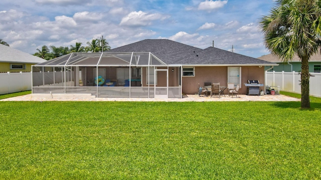 back of property with a lawn, a patio area, and a lanai