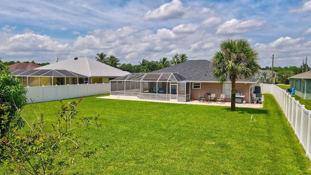 view of yard with glass enclosure and a patio