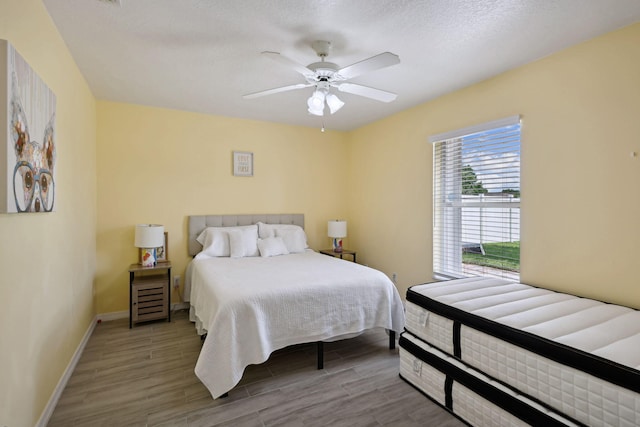 bedroom featuring ceiling fan, a textured ceiling, and hardwood / wood-style flooring