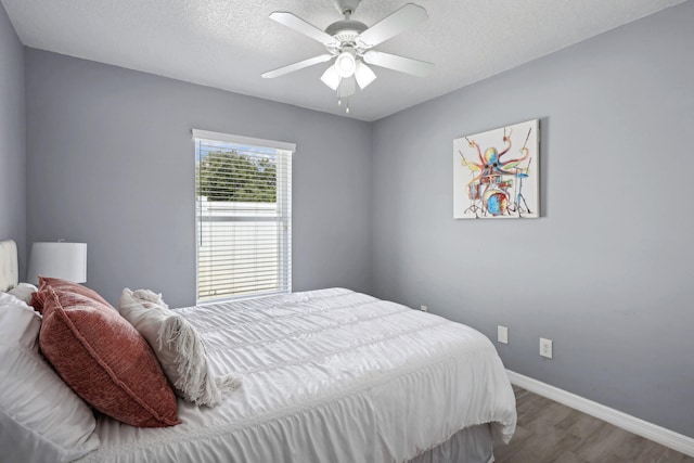 bedroom featuring ceiling fan, a textured ceiling, and hardwood / wood-style flooring