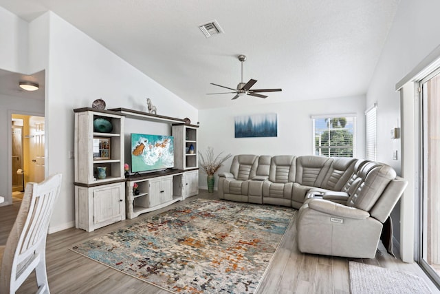 living room with light hardwood / wood-style floors, high vaulted ceiling, and ceiling fan