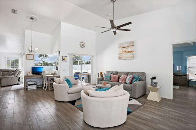 living room featuring plenty of natural light, high vaulted ceiling, ceiling fan with notable chandelier, and dark hardwood / wood-style flooring