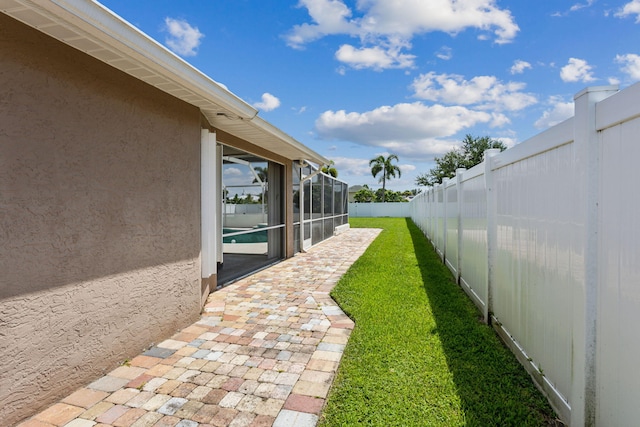 view of yard featuring a swimming pool and glass enclosure