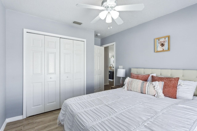 bedroom featuring ceiling fan, a closet, and hardwood / wood-style flooring