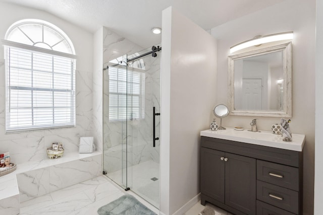 bathroom with plenty of natural light, a shower with door, and vanity