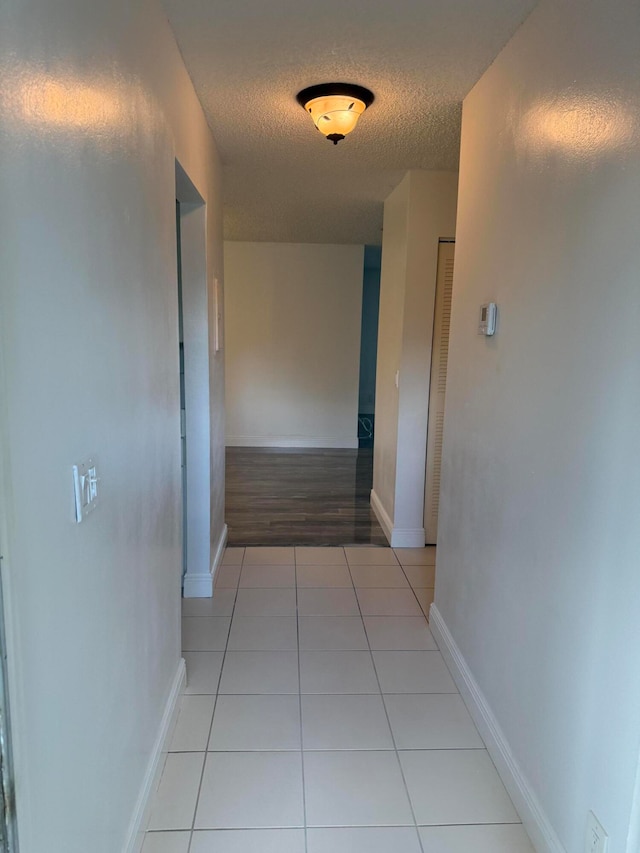 corridor featuring light hardwood / wood-style floors and a textured ceiling