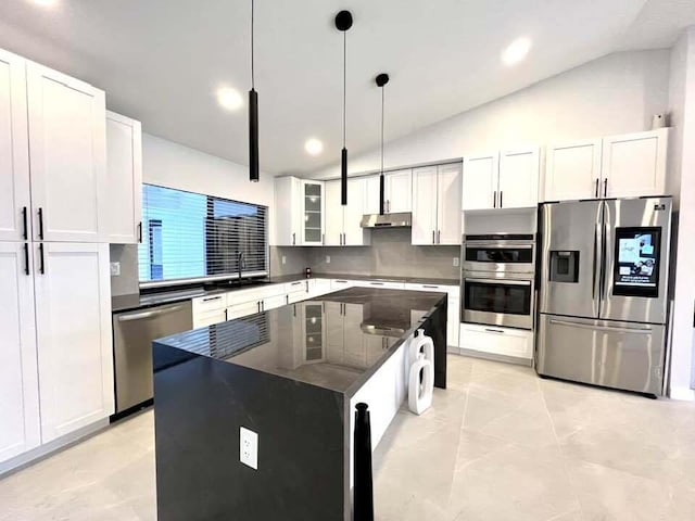 kitchen with a center island, white cabinets, vaulted ceiling, and appliances with stainless steel finishes