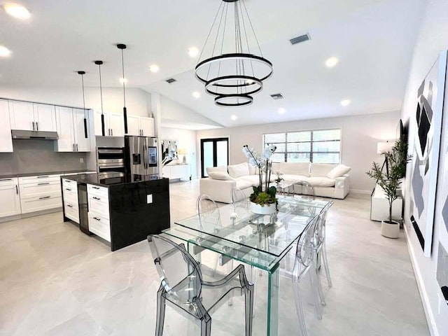 kitchen featuring decorative light fixtures, lofted ceiling, stainless steel fridge with ice dispenser, and white cabinets