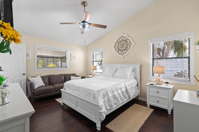 bedroom featuring dark hardwood / wood-style flooring, multiple windows, vaulted ceiling, and ceiling fan