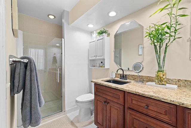 bathroom with vanity, tile patterned flooring, a shower with door, and toilet