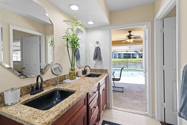 bathroom with vanity, a water view, and ceiling fan