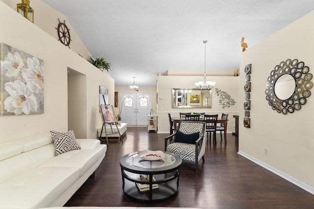 living room featuring lofted ceiling, dark hardwood / wood-style floors, and a notable chandelier