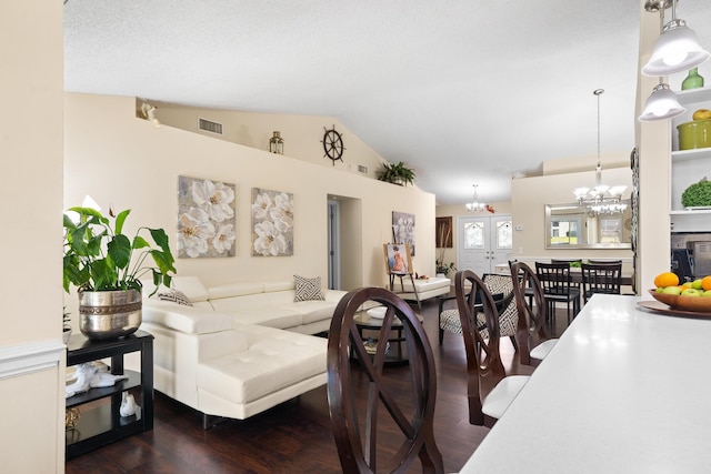 living room with dark hardwood / wood-style flooring, a notable chandelier, and lofted ceiling