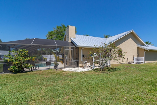 back of house with a lawn, a patio, and glass enclosure