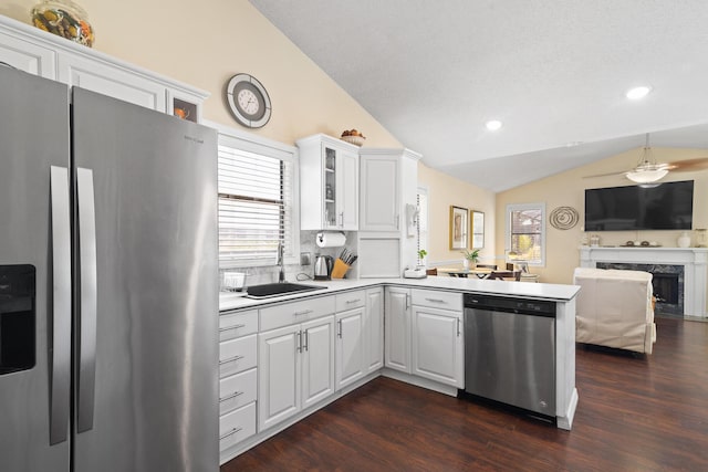 kitchen with white cabinetry, sink, kitchen peninsula, and appliances with stainless steel finishes