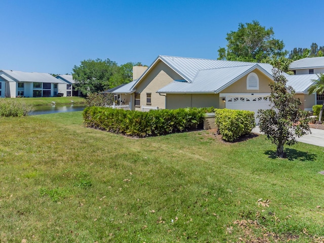 view of front of home featuring a garage, a water view, and a front yard