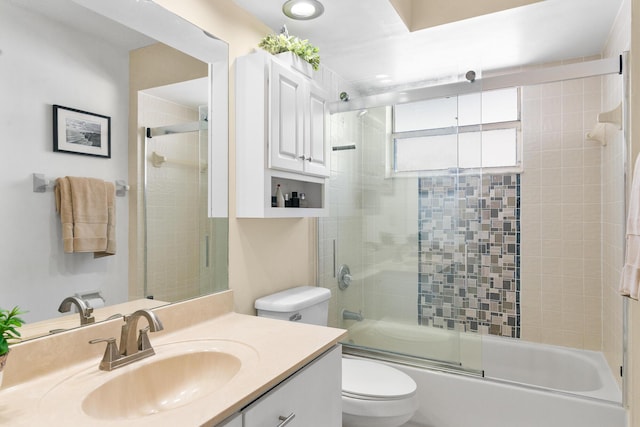 full bathroom with enclosed tub / shower combo, vanity, and toilet