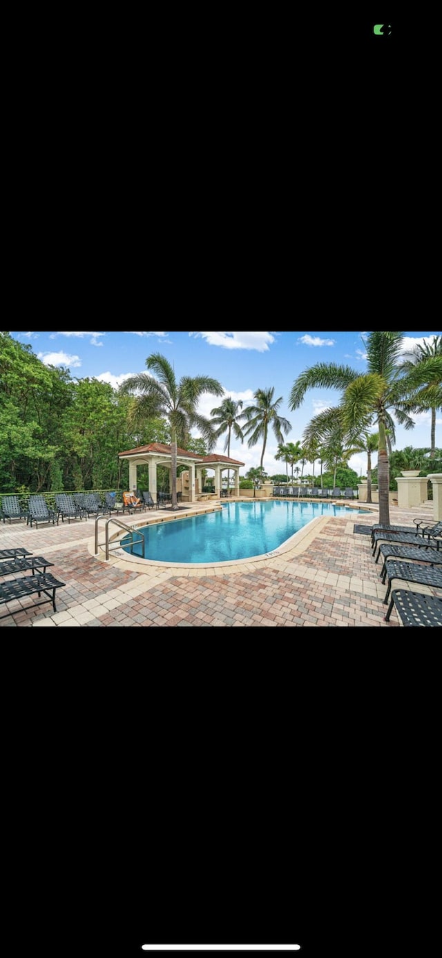 pool featuring fence and a patio area