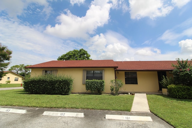 ranch-style home featuring a front lawn