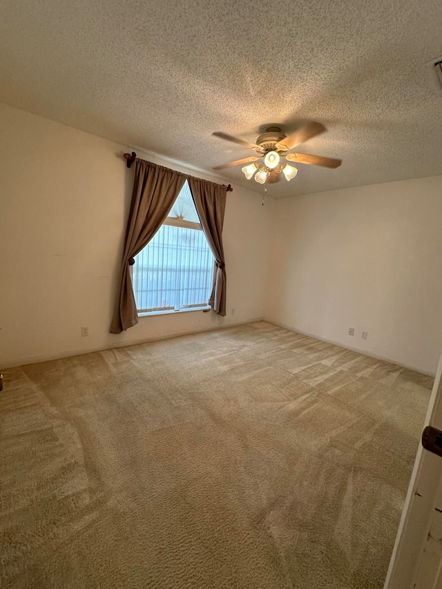 unfurnished room with ceiling fan, carpet, and a textured ceiling