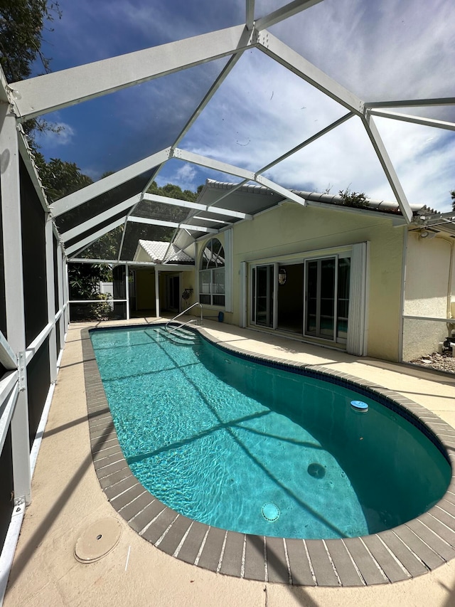 view of pool featuring a patio and glass enclosure