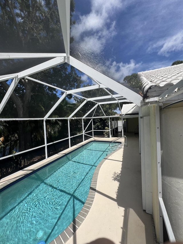 view of swimming pool with a lanai and a patio