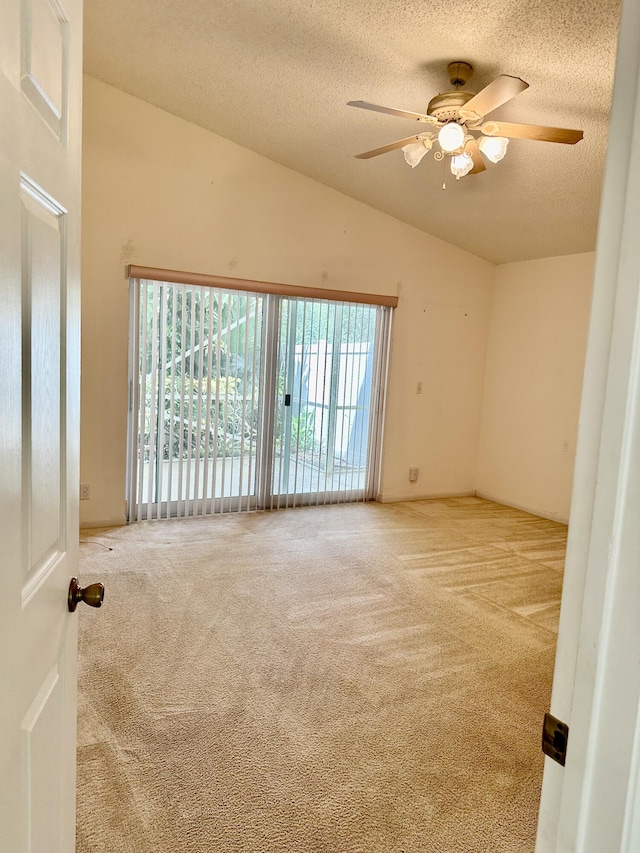 spare room with vaulted ceiling, light colored carpet, ceiling fan, and a textured ceiling