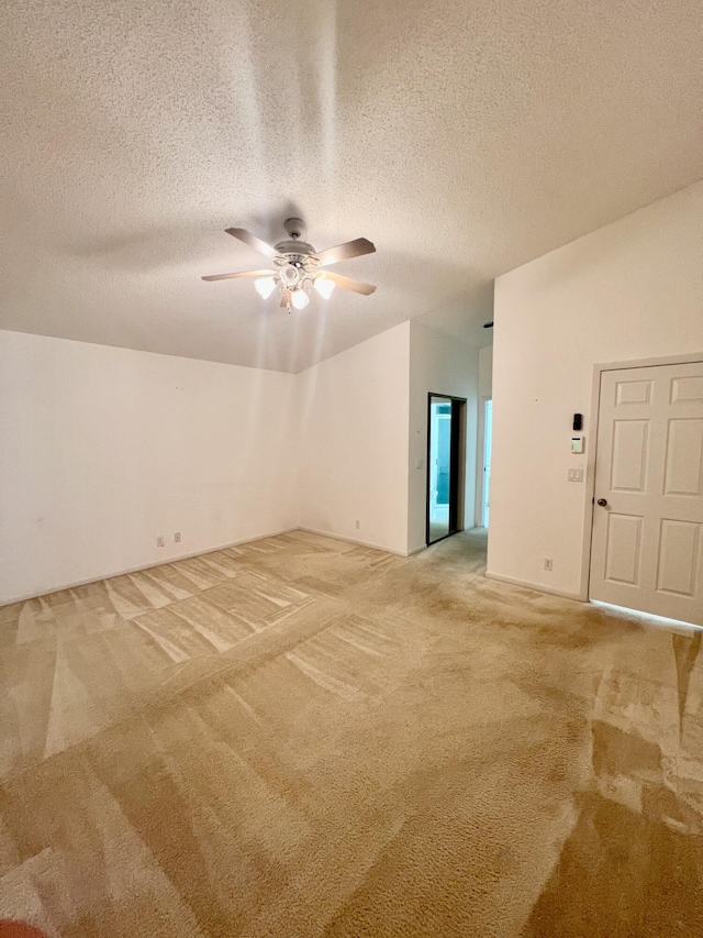 carpeted spare room with a textured ceiling and ceiling fan