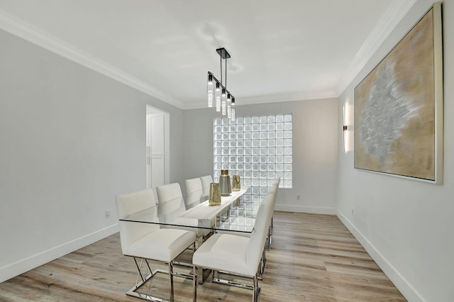 dining space featuring light wood-type flooring and ornamental molding