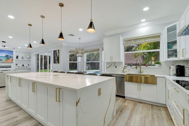 kitchen with light hardwood / wood-style floors, sink, white cabinets, a center island, and hanging light fixtures