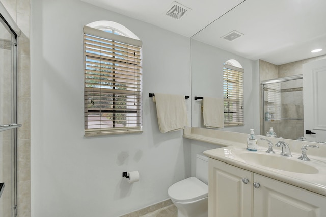 bathroom featuring toilet, vanity, and walk in shower