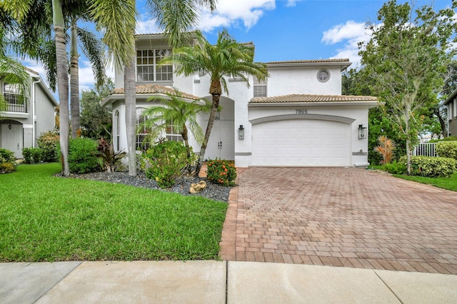 mediterranean / spanish-style home with a garage and a front lawn